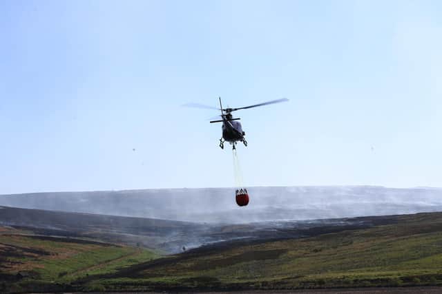 A helicopter drops water during a moorland fire at Saddleworth Moor, June 2018. Picture: Danny Lawson/PA