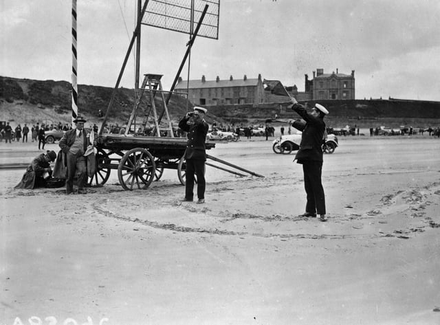 June 1922:  Coastguards signalling the results of races on the beach at Saltburn.  (Photo by Topical Press Agency/Getty Images)