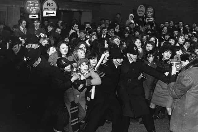 1964:  Policemen struggle to control an excited crowd of young female Beatles fans.  (Photo by Keystone/Getty Images)