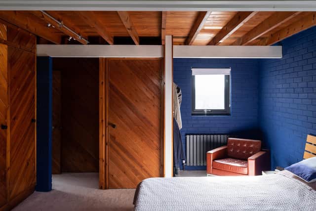 One of the three bedrooms, which has original wood cladding