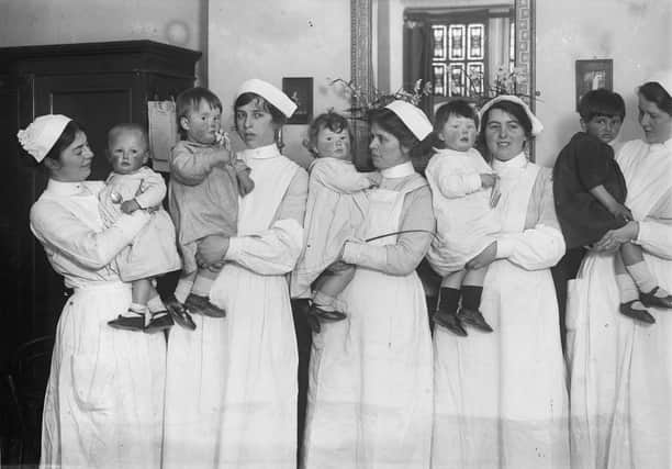 April 1916:  Nurses holding babies of different nationalities at St Mary's Nursery College in Hampstead, north London. From left to right, the children are Japanese, Scottish, Belgian, English and Indian.  (Photo by Topical Press Agency/Getty Images)