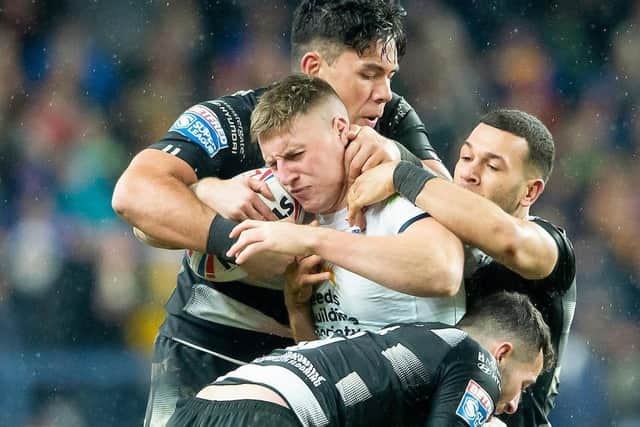 BODIES ON LINE: Leeds' Alex Mellor is tackled by Hull pair Andre Savelio and Carlos Tuimavave.