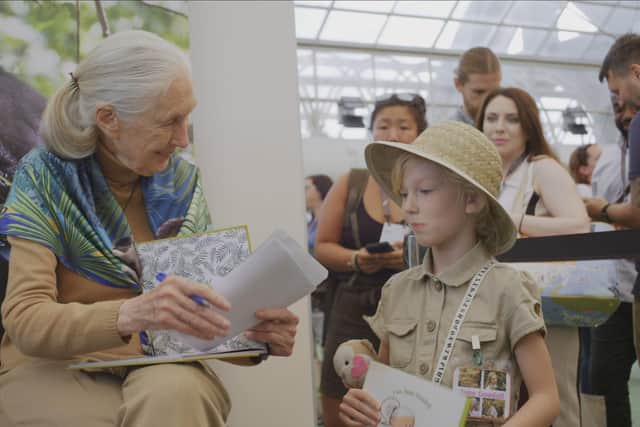 Dr. Jane Goodall signing book for young girl at Esri Conference in 2019. Picture: PA Photo/National Geographic/Michael Haertlein.