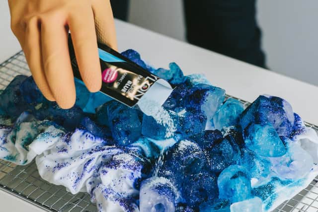 To make an Ice Dye T-shirt or shirt, sprinkle the dye onto the crumpled garment and ice cubes.
