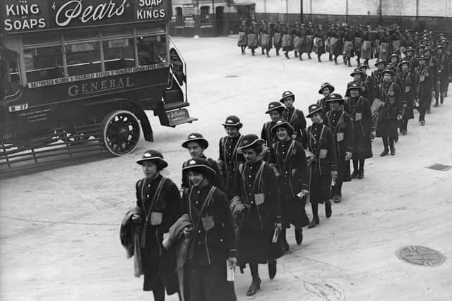 September 1917:  A line of bus conductorettes marching into a depot where their buses are parked.  (Photo by Topical Press Agency/Getty Images)