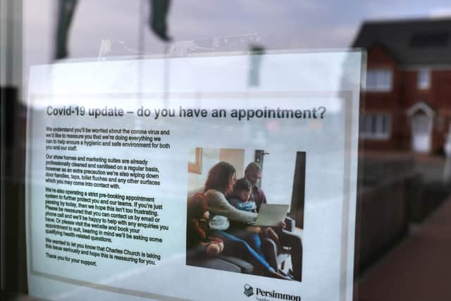 A sign regarding coronavirus in the window of a sales office at Persimmon Homes in Larbert in Scotland