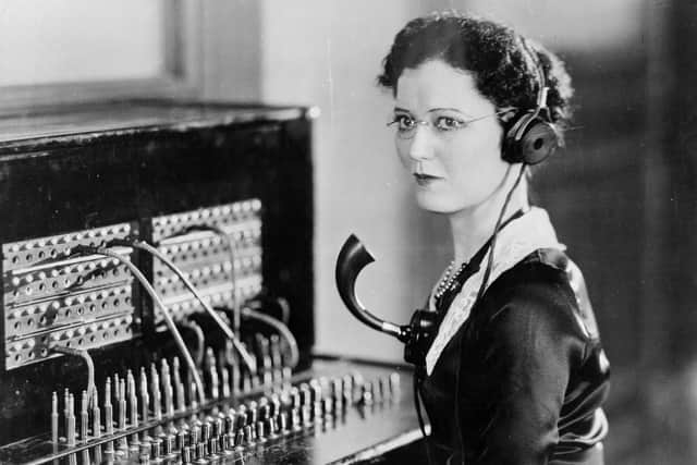 circa 1935:  A telephone operator with headphones and a mouthpiece at a switchboard.  (Photo by General Photographic Agency/Getty Images)