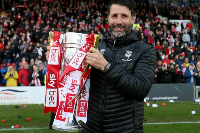 Winner: Lincoln City manager Danny Cowley celebrates with the League Two trophy at Sincil Bank.