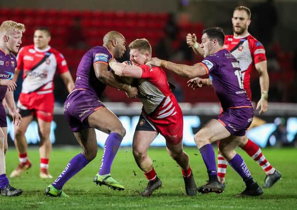 IN THE THICK OF IT: Joe Wardle, right, tackles Salford's Luke Yates with Huddersfield team-mate Michael Lawrence at the AJ Bell Stadium earlier this season. Picture by Alex Whitehead/SWpix.com