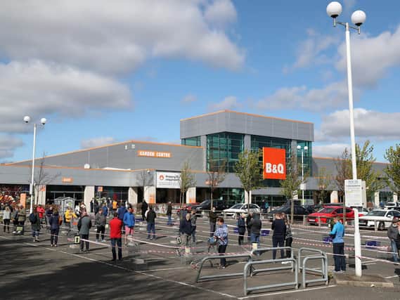 Members of the public follow social distancing guidelines and queue in the car park of B&Q in Edinburgh
