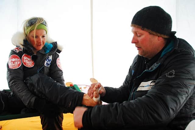 TOUGH GOING: Helen Skelton has her feet checked during a 500-mile dash to the South Pole for Sport Relief. The presenter attempted to set a record for the fastest 100km kite surf, covering the distance across Antarctica in seven hours and 55 minutes. Picture: Mike Carling/Sport Relief/PA