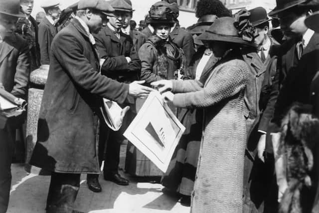 A woman buys a souvenir print of the White Star liner Titanic shortly after the disaster which claimed over 1,500 lives, 1912.   (Photo by Topical Press Agency/Getty Images)