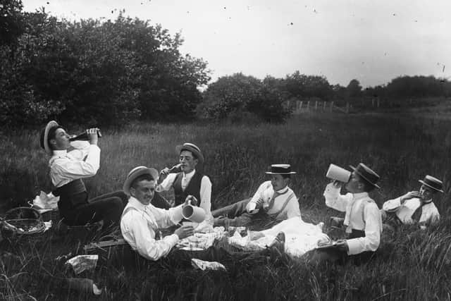 A group of shirtsleeved men enjoying a picnic in a field.   (Photo by F J Mortimer/Getty Images)
