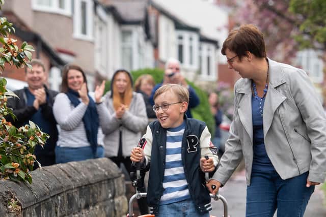Tobias Weller, who has cerebral palsy and autism, walks along the street outside his home in Sheffield, South Yorkshire. Photo credit: Joe Giddens / PA Wire.