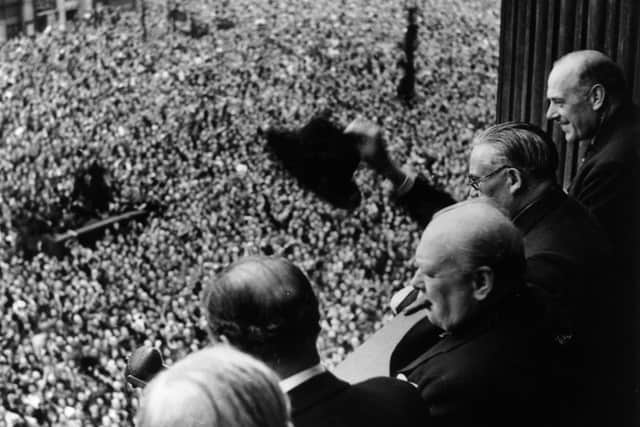 Winston Churchill waves to the VE Day crowds who had gathered on Whitehall.