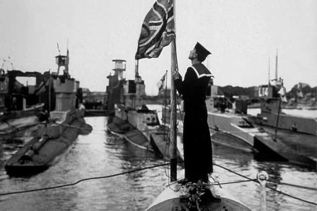 circa 1940:  The Union Jack being raised on board a British submarine.  (Photo by Keystone/Getty Images)
