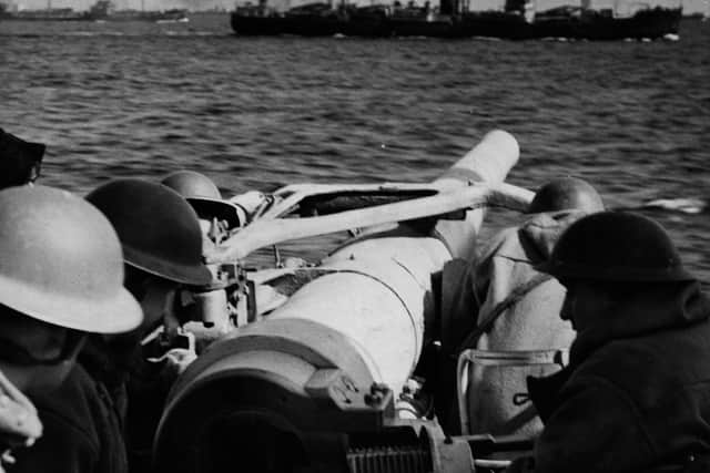 27th May 1941:  Seamen aboard the British destroyer aim a gun - with one of the convoy in the background.  (Photo by Fox Photos/Getty Images)