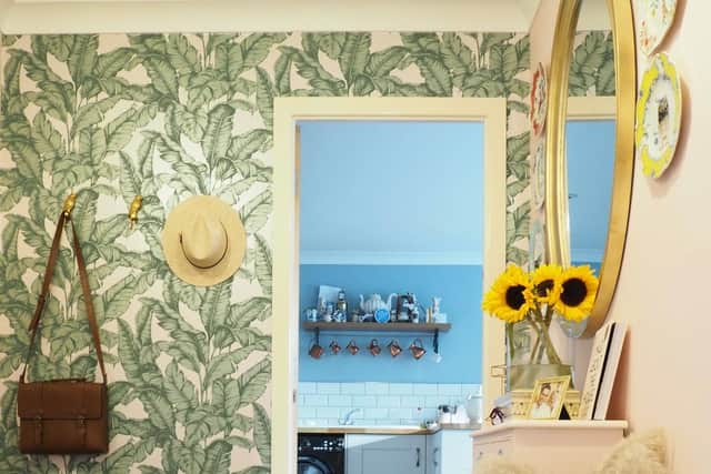 The hall was uninspiring before its makeover with palm wallpaper and a cabinet to hide the storage heater