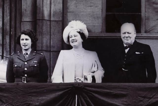 A VE Day scene at Buckingham Palace, showing Princess Elizabeth (now Queen Elizabeth II), The Queen (Queen Mother) and Winston Churchill on the balcony of the palace.
