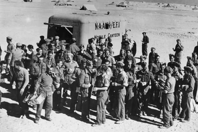 1942:  A NAAFI canteen brings welcome chocolate, tea, cigarettes and newspapers to 'D Company' of the 4th Battalion of the Green Howards (an infantry regiment of the British Army), in the Western Desert south of Tobruk, Libya, World War II. The unit were later captured at the Battle of Gazala on 1 June 1942.  (Photo by Fox Photos/Getty Images)