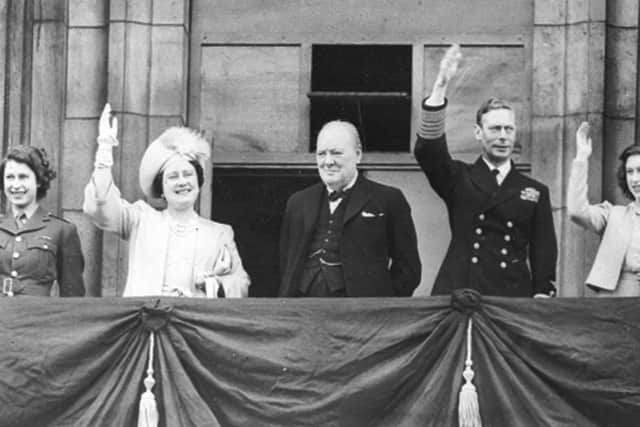 Winston Churchill looks on as King George VI, Queen Elizabeth, then-Princess Elizabeth (left) and Princess Margaret, wave to crowds gathered below, from the balcony of Buckingham Palace on VE Day, May 8, 1945. (AP)