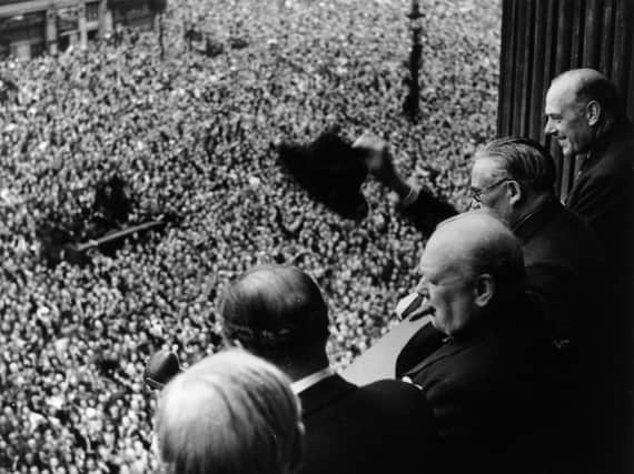 Prime Minister Winston Churchill waves to crowds gathered in Whitehall on VE Day, May 8, in 1945. (Getty Images)