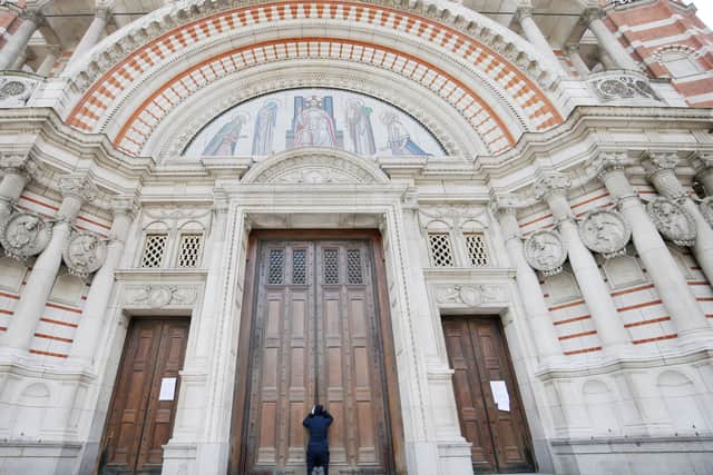 A woman prays at the closed doors of Westminster Cathedral.