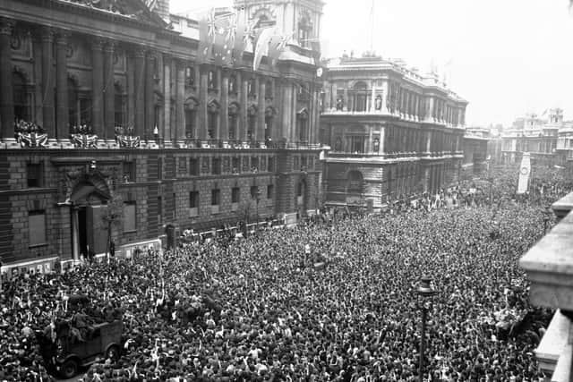Crowds in Whitehall wait to be address by Winston Churchill on VE Day after Germany's unconditional surrender.
