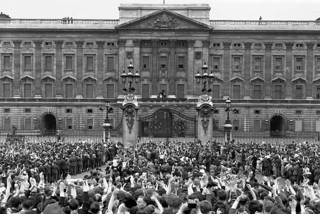 A vast crowd assembles in front of Buckingham Palace, London to cheer Britain's Royal family as they come out on the balcony, centre, minutes after the official announcement of Germany's unconditional surrender