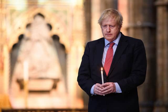 Boris Johnson lights a candle at the Tomb of trhe Unknown Soldier in Westminster Abbey to mark VE Day.