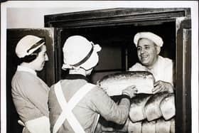 Mr Herbert Franks, the baker at Guy's Hospital in London, handing out loaves of bread to nurses at the hospital, London, England. Guy's is the only London Hospital with its own bakehouse for baking its own bread. Mr Herbert Franks, the baker, has worked in Guy's bakehouse for twenty five years and every day produces a regular supply for hospital patients and staff. (Photo by William Vanderson/Fox Photos/Hulton Archive/Getty Images)