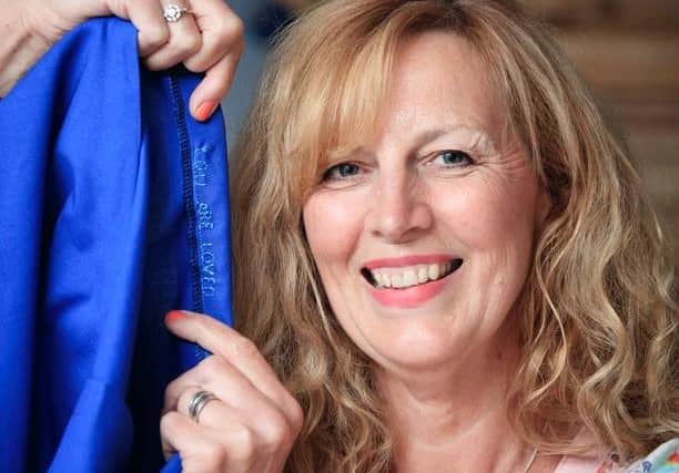 Jen Legg, from Maltby, North Yorkshire, has added the message "You Are Loved" to some of her donated scrubs. Photo credit: Danny Lawson/PA