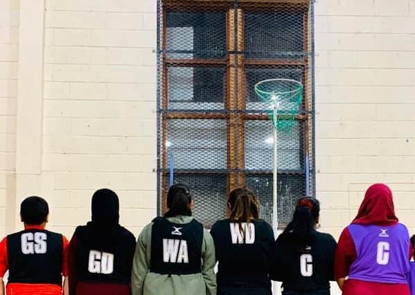 making a stand: Musarath Soofi takes a picture of the women in her netball programme in Bradford, all facing away from the camera as per their religious beliefs.