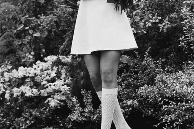 Portrait of actress Britt Ekland, wearing a white mini dress and knee socks, holding a bouquet of Red Planet 'Rose of the Year', at the Chelsea Flower Show, London, May 18th 1970. (Photo by Leonard Burt/Central Press/Getty Images)