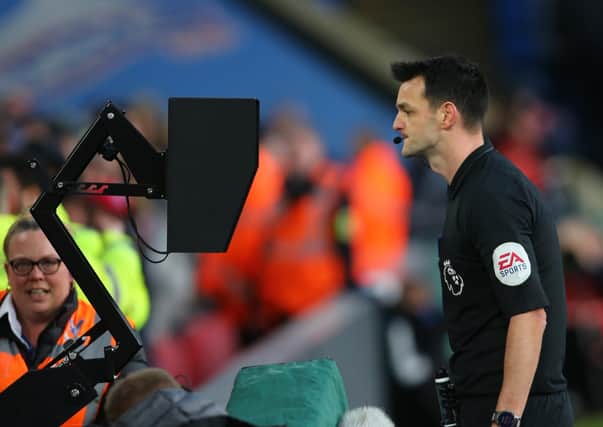 Referee Andy Madley: Consulting the VAR pitch side screen, leading to a red card reversal during the Premier League match between Crystal Palace and Sheffield United at Selhurst Park. Picture: Paul Terry/Sportimage