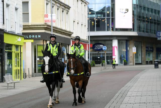 Police patrol the deserted streets of Leeds city centre during the lockdown
