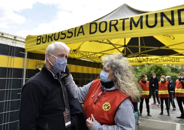 A TV crew member has his temperature checked before entering the stadium for the German Bundesliga soccer match between Borussia Dortmund and Schalke 04 in Dortmund, Germany. PA Photo. Picture date: Saturday May 16, 2020. Erling Haaland carried on where he left off before the coronavirus suspension as the teenager kicked off Borussia Dortmund’s thumping victory against rivals Schalke 04 in an entertaining, if surreal, return to Bundesliga action.
