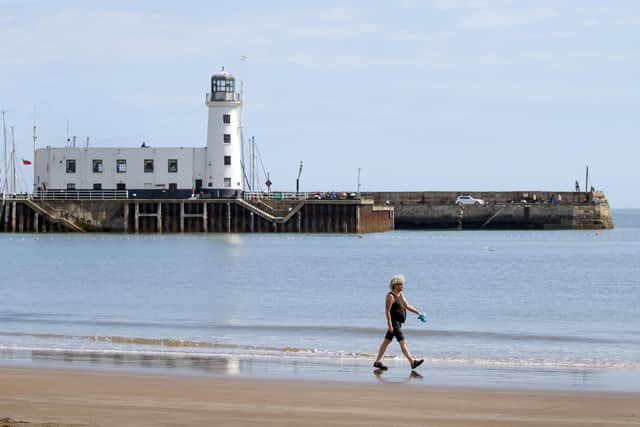 A lone walker on the beach near Whitley Bay.