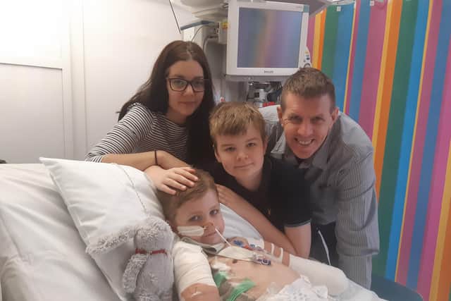 Luke in Sheffield Children's Hospital with mum Christine, Dad Adam and brother Harry
