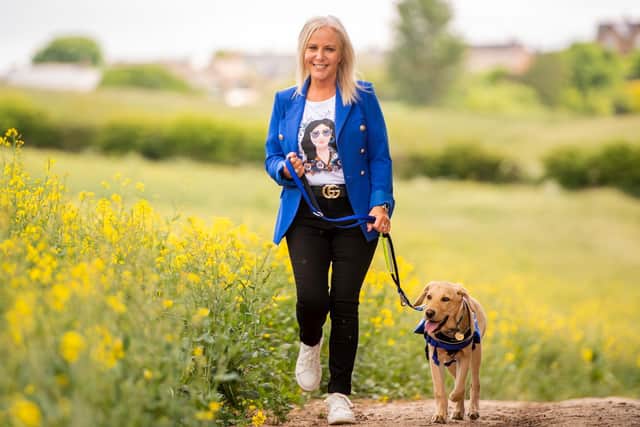 Deana Sampson, 57, from Sheffield,on a walk with six-month-old Regis, a golden Labrador from Support Dogs in Sheffield