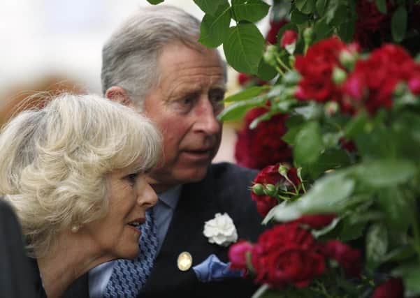 The Prince of Wales and Duchess of Cornwall inspect a Highgrove rose.