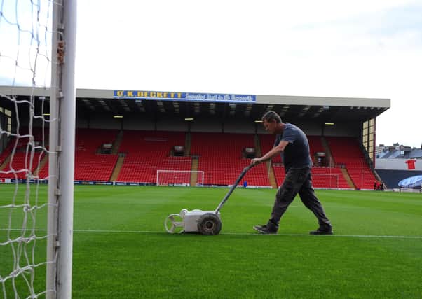 Pitching in: A groundsman paints white lines on the pitch at Oakwell. Picture: Tony Johnson