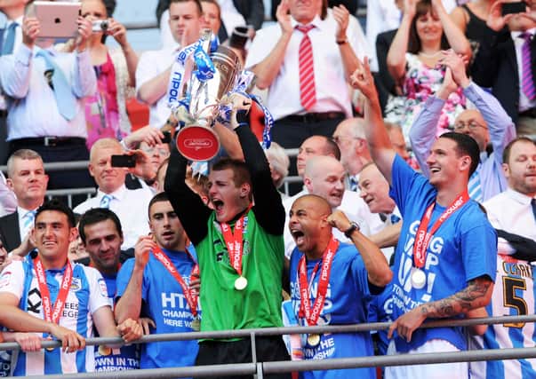 Huddersfield Town's Alex Smithies lifts the trophy at Wembley. Picture: Jonathan Gawthorpe.