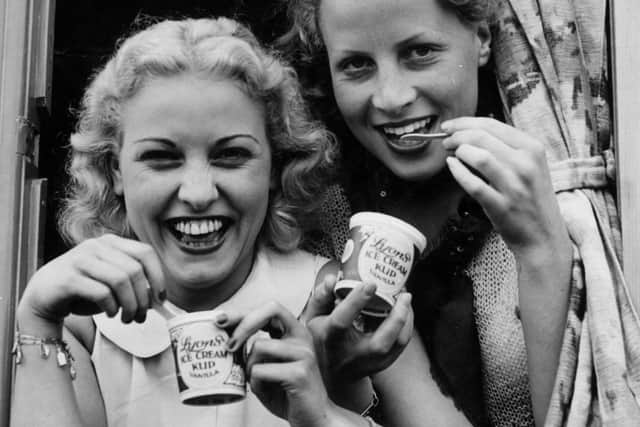 August 1937:  Two young women enjoy tubs of ice-cream.  (Photo by Fox Photos/Getty Images)