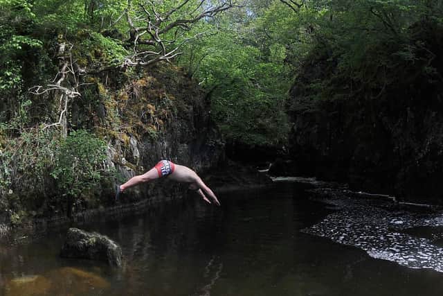 Wild swimmer Johnny Hartnell dives into the River Doe near his home in Ingleton