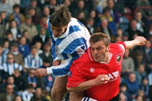 Huddersfield's Tom Cowan battles wit Barnsley's Neil Redfearn.