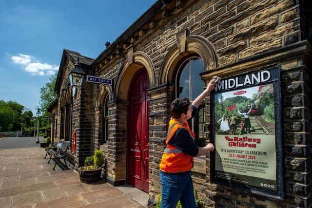 KWVR volunteer Joseph Lockyer cleaning the station sign at Oakworth Station, where many scenes from the Railway Children were filmed. Events are planned in August for the 50th anniversary but the organisation's future is uncertain. Picture: Bruce Rollinson.