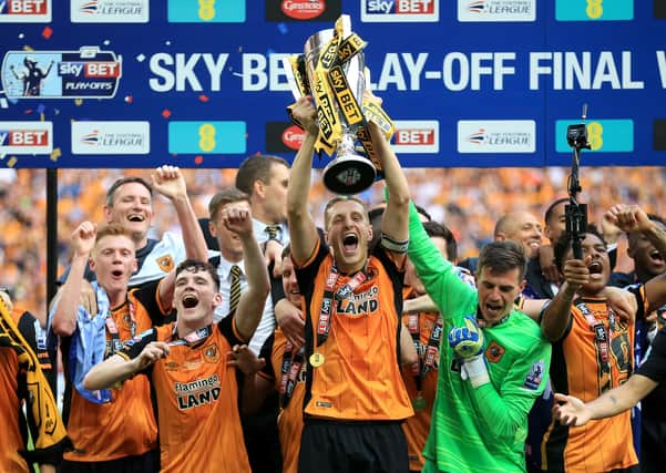 Hull City's Michael Dawson lifts the trophy after winning the Championship Play-off Final at Wembley against Sheffield Wednesday in 2016.