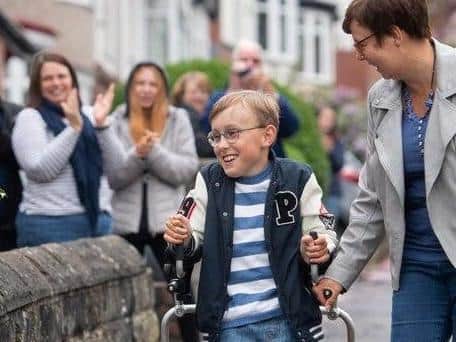 Tobias Weller, who has cerebral palsy and autism, pictured during hiss epic challenge along the street outside his home in Sheffield, South Yorkshire. Photo credit: Joe Giddens / PA