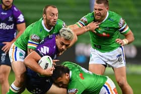 Got him: Elliott Whitehead, right, moves in as Melbourne Storm's Tino Fa'asuamaleaui  is tackled by the Canberra Raiders defence. Picture: Quinn Rooney/Getty Images